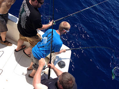 Oregon Inlet offshoe charter group bailing mahi at the transom.